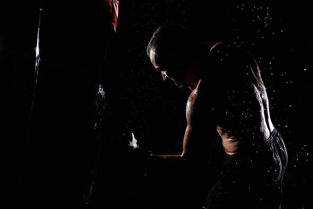 Молодой человек с мышцами тренируется и бьет - Фото, изображение
