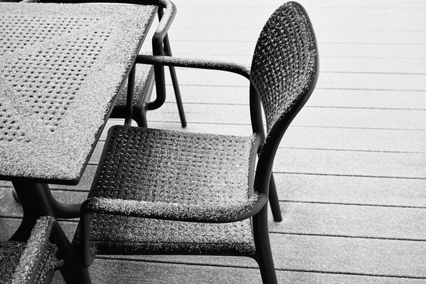 parties abstraites recouvertes de neige de la chaise et de la table de couleur noire et gros plan à l'extérieur avec de la neige blanche - Photo, image