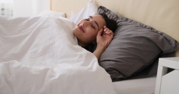 Счастливая женщина просыпается и растягивается в постели  - Кадры, видео