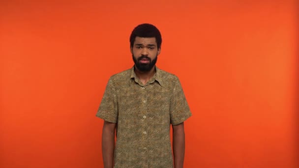 displeased bearded african american man talking isolated on orange - Imágenes, Vídeo