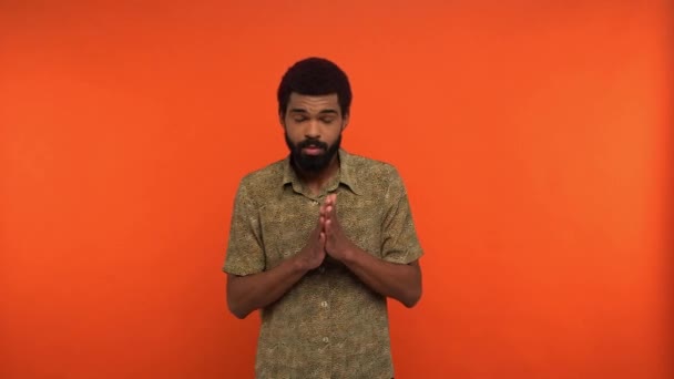 afro-amerikai férfi dörzsöli kezét, és mutatja győzelem gesztus elszigetelt narancs - Felvétel, videó