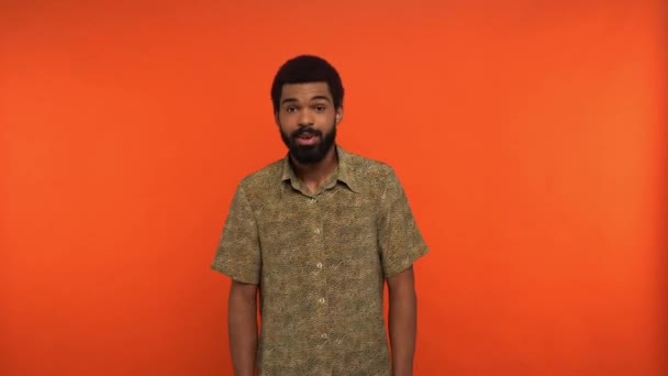 espantado afro-americano homem mostrando vitória gesto isolado em laranja - Filmagem, Vídeo
