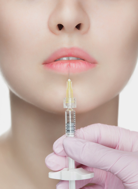Der Kosmetologe spritzt dem Patienten Botulinumtoxin in die Lippen. Kosmetologie Hautpflege. - Foto, Bild