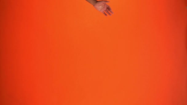 幸せなアフリカ系アメリカ人男性の垂直ビューがオレンジに隔離されたヘッドフォンで - 映像、動画