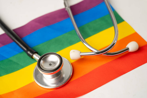 Musta stetoskooppi sateenkaaren lippu tausta, symboli LGBT ylpeys kuukausi juhlia vuosittain kesäkuussa sosiaalinen, symboli homo, lesbo, biseksuaali, transsukupuolinen, ihmisoikeudet ja rauha. - Valokuva, kuva