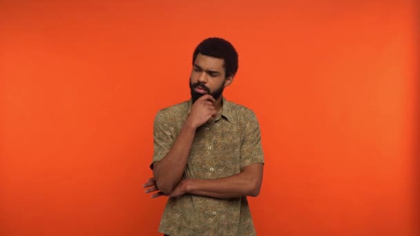 nachdenklicher afrikanisch-amerikanischer Mann denkt isoliert auf orange - Filmmaterial, Video