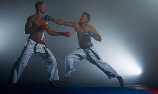 Karate muži s černým pásem pózování, mistr světa na černém pozadí studio shot - Fotografie, Obrázek