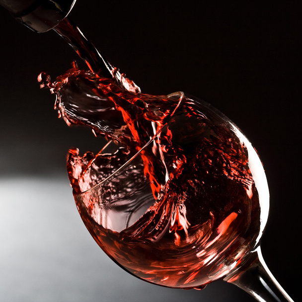 Красное вино льется в бокал вина
 - Фото, изображение