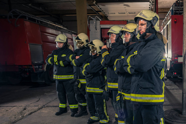 Groupe de pompiers en confiance avec les armes croisées. Pompiers prêts pour le service d'urgence. - Photo, image