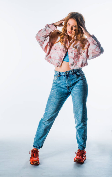 ody shot de una chica moderna y fresca que usa jeans azules, chaqueta colorida y zapatillas rojas - Foto, Imagen