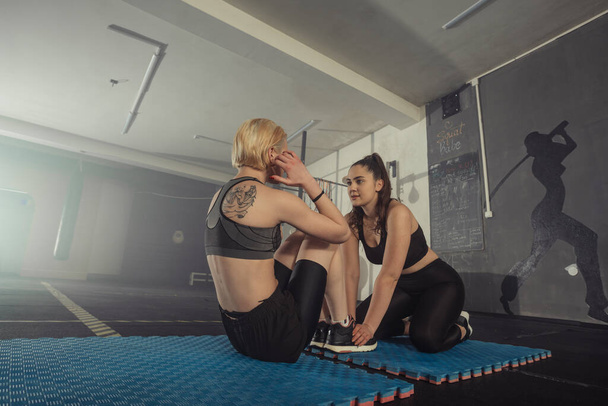 Femmes en noir et blanc vêtements de sport sur un vrai corps de groupe Entraînement de combat dans le train de gymnastique pour se battre, kickboxing avec un entraîneur. - Photo, image