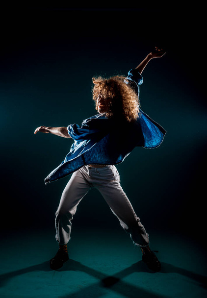 Artista de silueta de danza moderna practicando movimientos de baile en el estudio - Foto, imagen