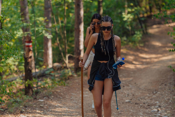 Schwestern wandern im Rucksack durch schöne Wälder und genießen die Natur. Weibliche Bindung. - Foto, Bild