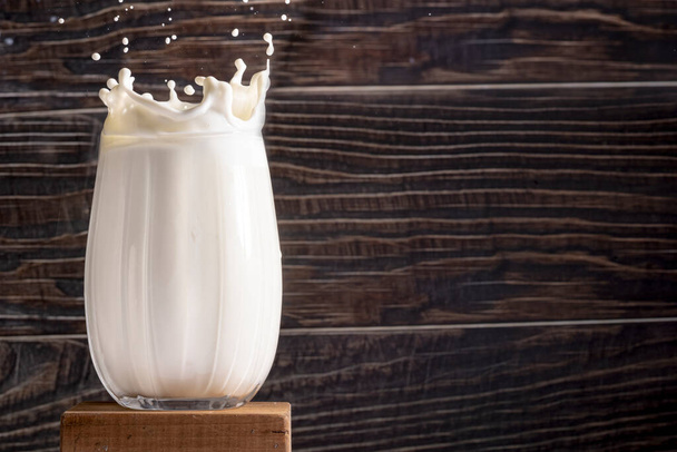 Glass of milk and bottle on wooden background - Photo, Image