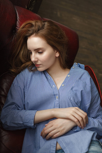 φυσικό χαριτωμένο καυκάσιος λεπτή γυναίκα με μακριά καστανά μαλλιά βρίσκεται στον καναπέ στο σπίτι - Φωτογραφία, εικόνα