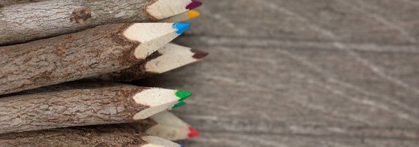 lápis de cor encadernado feito de madeira real, não tratada, único com casca de árvore real em uma placa de madeira marrom para estudantes e artistas. Horizontal - Foto, Imagem