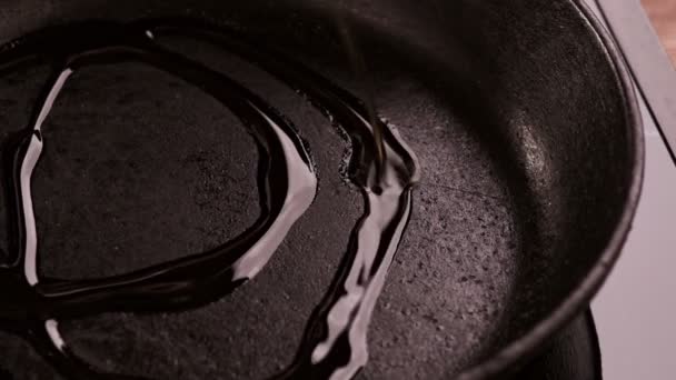 Großaufnahme eines Kochs, der Olivenöl in eine Pfanne gießt. Öl in die Pfanne gießen - fertig zum Braten. - Filmmaterial, Video