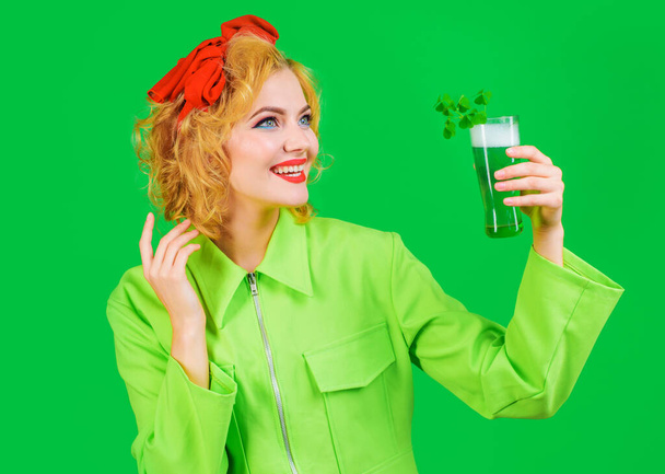Saint-Patricks. Femme souriante avec un verre de bière verte. Boisson verte au trèfle. Traditions irlandaises. - Photo, image