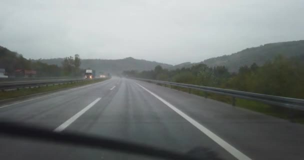 widok na autostradę deszczową z przedniej szyby samochodu - Materiał filmowy, wideo