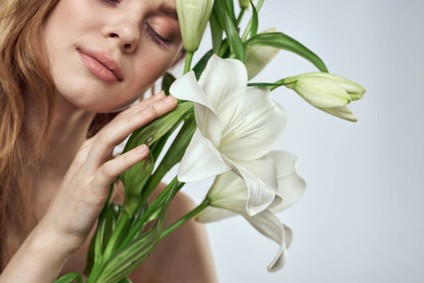 明るい背景に白い花を持つ美しい女性の肖像画 - 写真・画像