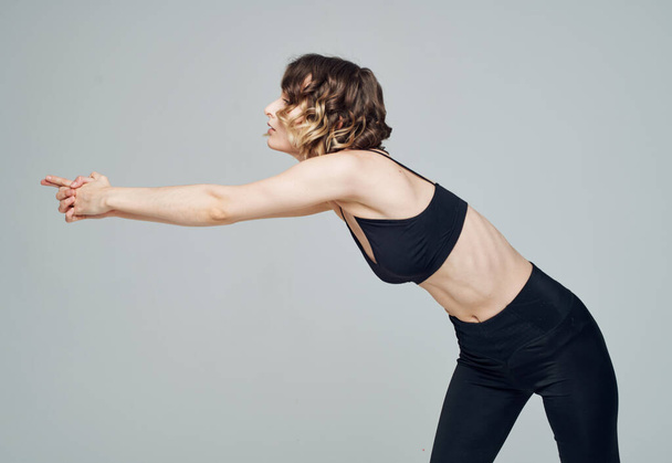 Женщины в спортивной одежде занимаются фитнесом на сером фоне в леггинсах обрезанным видом - Фото, изображение