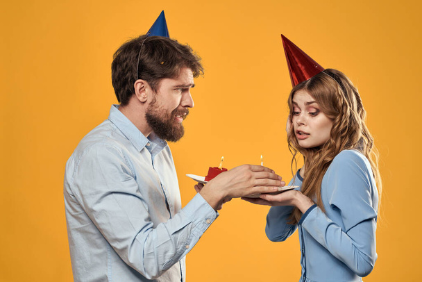 Syntymäpäiväjuhla mies ja nainen korkki kakku keltaisella taustalla rajattu näkymä - Valokuva, kuva