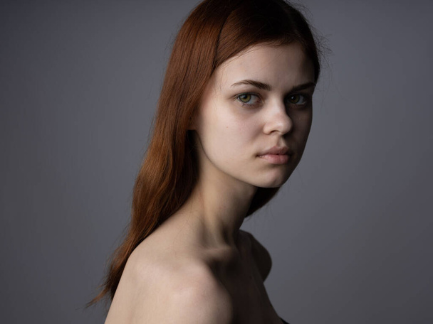 Kobieta portret na szarym tle uroczy model czerwony włosy przycięte wygląd - Zdjęcie, obraz