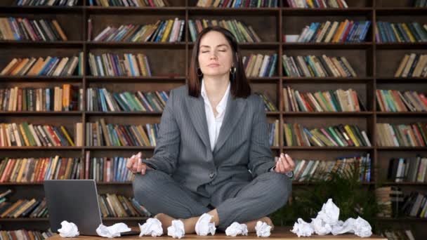 Krótkowłosy bizneswoman medytuje siedzi w pozycji do jogi - Materiał filmowy, wideo