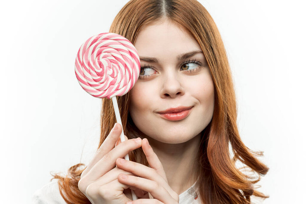 cheerful pretty woman with a round lollipop near face emotions joy - Foto, afbeelding
