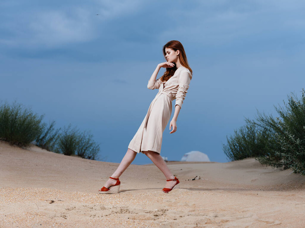 Una mujer camina por la playa en sandalias rojas con un amplio zancada - Foto, Imagen
