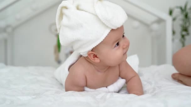 Mooie lachende baby: Een prachtige kleine baby ligt op het bed en glimlacht met een mooie achtergrond met zachte focus. - Video