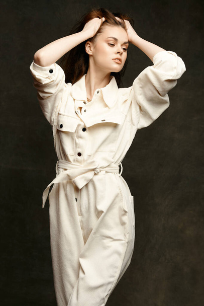 portrait of a brunette in a jumpsuit on a dark background gesturing with her hands Copy Space - Photo, Image