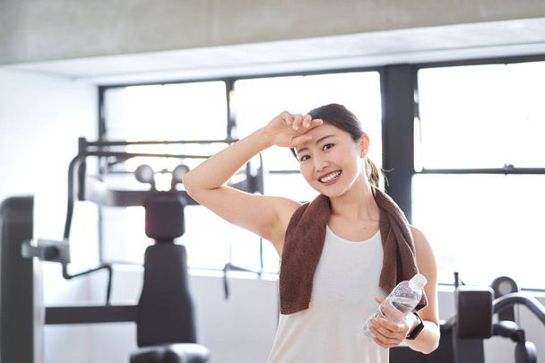 Asian woman sweating at the gym - Photo, image