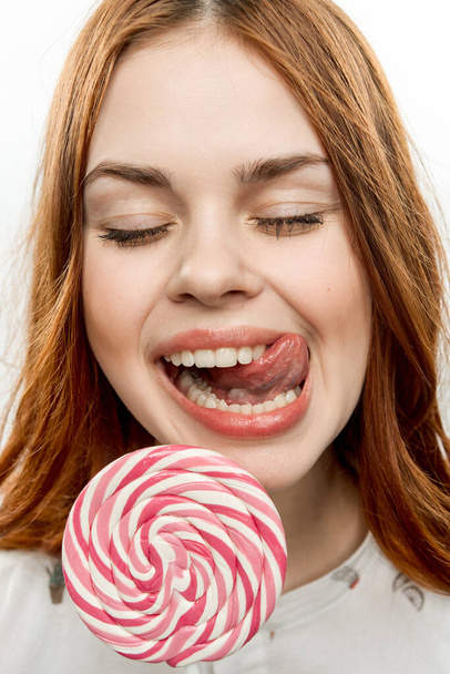 ładna rudowłosa kobieta jedzenie lizak radość emocje zbliżenie - Zdjęcie, obraz