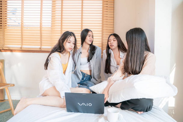 Asian business young beautiful sexy friends playing in the bed in front of laptop relaxed at her bed - Photo, Image