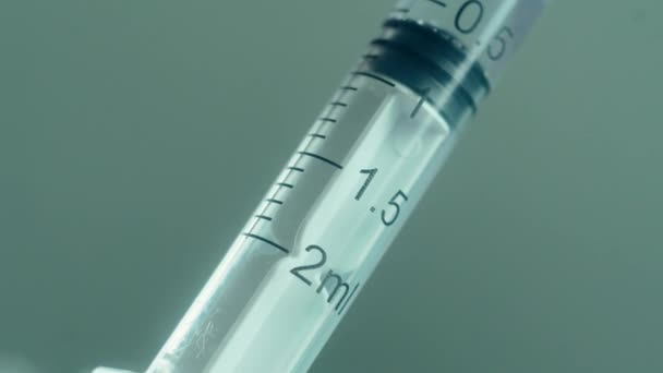 Le chercheur médical remplit la seringue avec un vaccin anti-coronavirus ou d'autres médicaments pharmaceutiques en macro - Séquence, vidéo