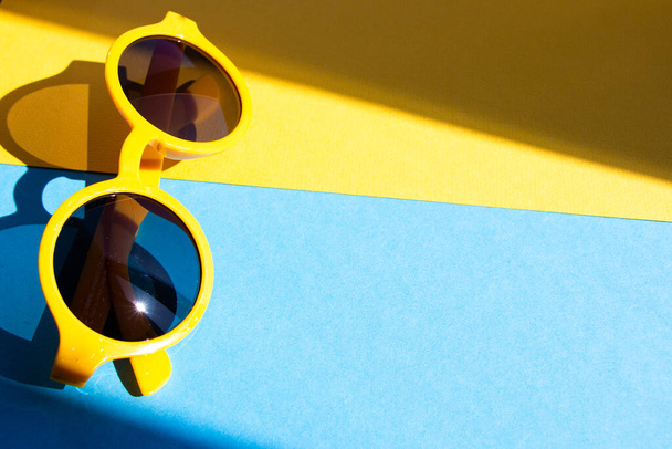 yellow rimmed sunglasses on blue blank background - Photo, Image