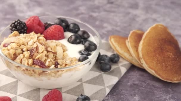 Granola met yoghurt en bessen in schaal op zwarte achtergrond  - Video