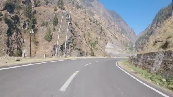 Empty long mountain rural road of National Highway 34 connecting Uttarkashi - Gangotri Road on the way to Harsil. POV of car driving on highway road Surrounded by mountains. - Metraje, vídeo