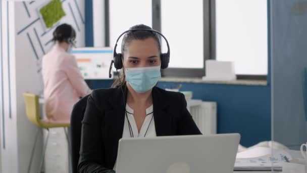 Podnikatelka s ochrannou maskou obličeje mluví do mikrofonu - Záběry, video