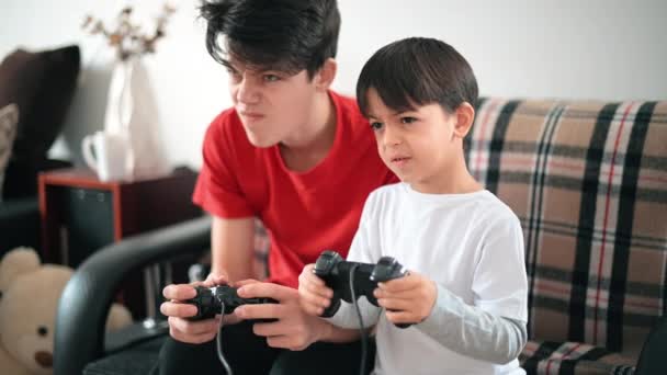 Deux frères jouent à des jeux de console en utilisant des contrôleurs. Différents âges - Séquence, vidéo