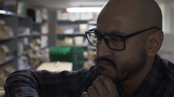 Ethnische Minderheit Erwachsene mit Glatze tragen Brillen, die das Kinn im Keller reiben. Abgeriegelt  - Filmmaterial, Video