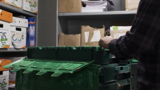Volwassen man opent langzaam groene plastic containerdeksel in kantoorkelder. Afgesloten. - Video