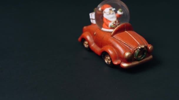 Winter speelgoed, de Kerstman in een rode auto brengt geschenken. Video met langzame zijdelingse beweging Kinderspeelgoed voor Kerstmis. - Video