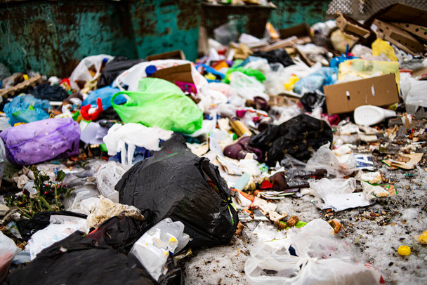 Σωρός σκουπιδιών σε χωματερή και αφθονία αποβλήτων, απορριμμάτων και ρύπανσης πλαστικών φιαλών και σακουλών στο έδαφος, ανακύκλωση αποβλήτων και κίνδυνος τοξικής περιβαλλοντικής δηλητηρίασης. - Φωτογραφία, εικόνα