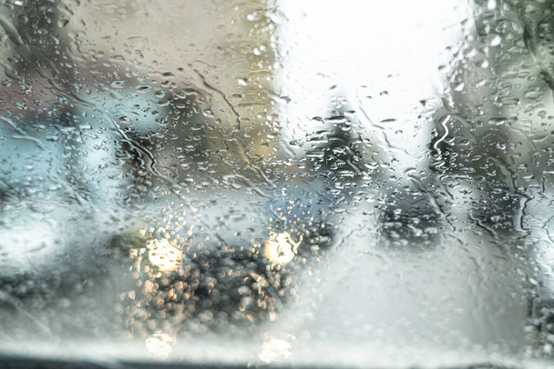 Światła samochodowe przez szkło w kroplach deszczu - Zdjęcie, obraz