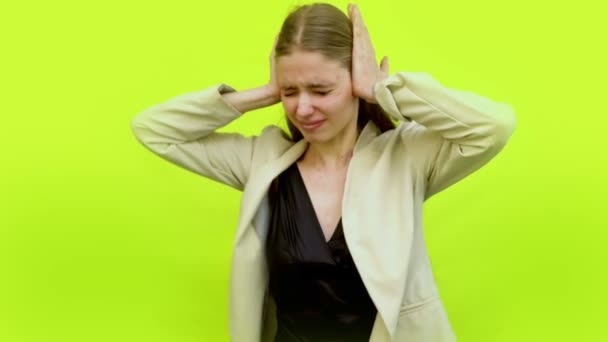 Γυναίκα πονοκέφαλος κλαίει καλύπτει τα αυτιά με παλάμες στο στούντιο χώρο - Πλάνα, βίντεο