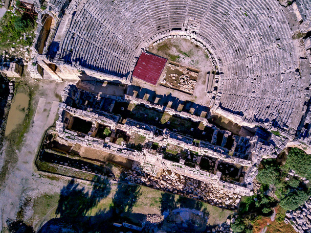 古代ギリシャのロックカットリュキア帝国円形劇場とミラの墓の高角度ドローンの空中ビュー(デムレ,トルコ) - 写真・画像
