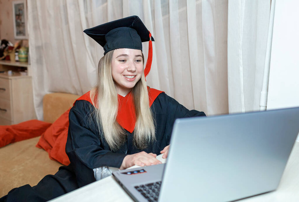 Εικονική τελετή αποφοίτησης. Φοιτητής που λαμβάνει συγχαρητήρια από την οικογένεια κατά τη διάρκεια διαδικτυακής βιντεοκλήσης - Φωτογραφία, εικόνα