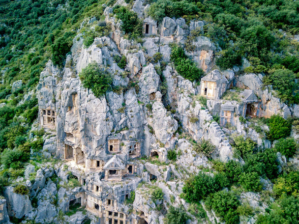 High angle drone aerial view of ancient greek rock cut tombs carved into cliffside in Myra (Demre, Turkey) - Photo, Image